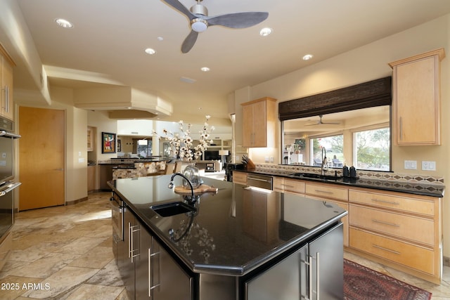 kitchen featuring kitchen peninsula, light brown cabinetry, a center island, and sink