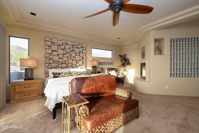 carpeted bedroom with ceiling fan, a raised ceiling, and a mountain view