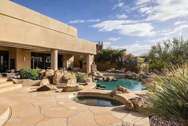 view of pool with an in ground hot tub and a patio