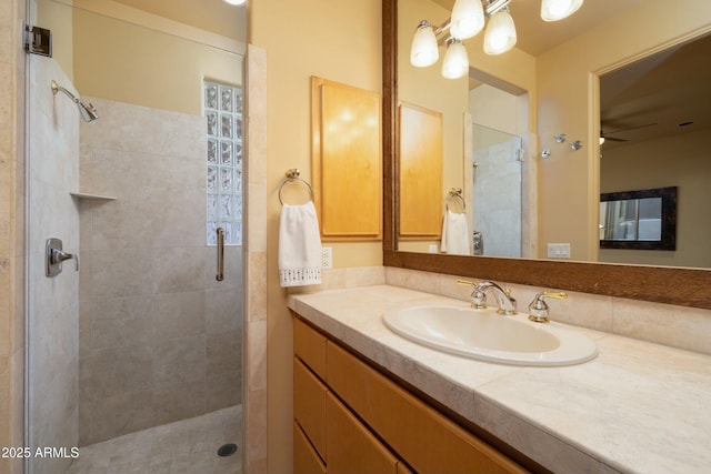 bathroom with vanity, a shower with door, and ceiling fan