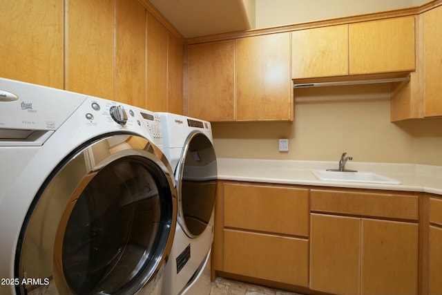 washroom featuring washer and dryer, cabinets, and sink