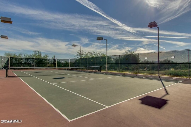 view of tennis court with basketball hoop