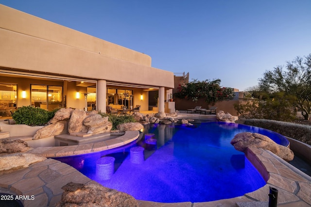 pool at dusk with a patio