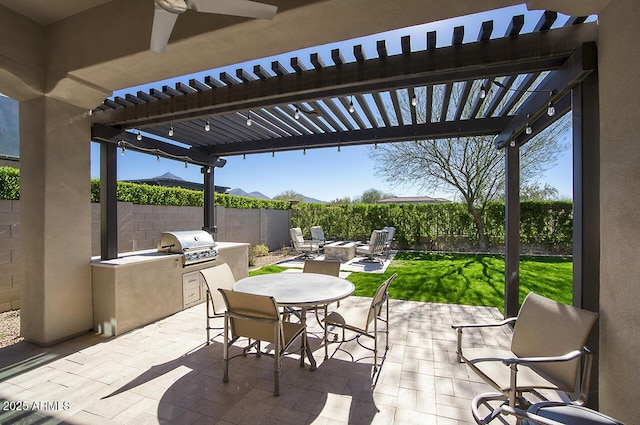 view of patio featuring a fenced backyard, area for grilling, exterior kitchen, a pergola, and outdoor dining space