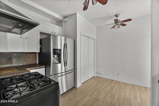 kitchen with tasteful backsplash, range hood, stainless steel fridge, black range with gas cooktop, and white cabinets