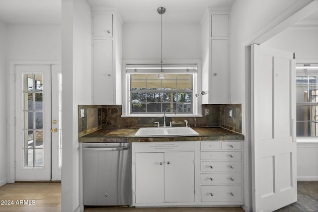 kitchen featuring white cabinets, pendant lighting, tasteful backsplash, and stainless steel dishwasher