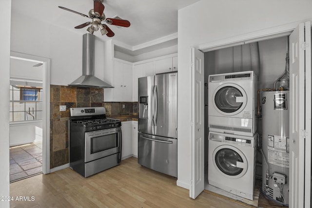 kitchen with white cabinetry, wall chimney exhaust hood, water heater, stacked washer and dryer, and appliances with stainless steel finishes