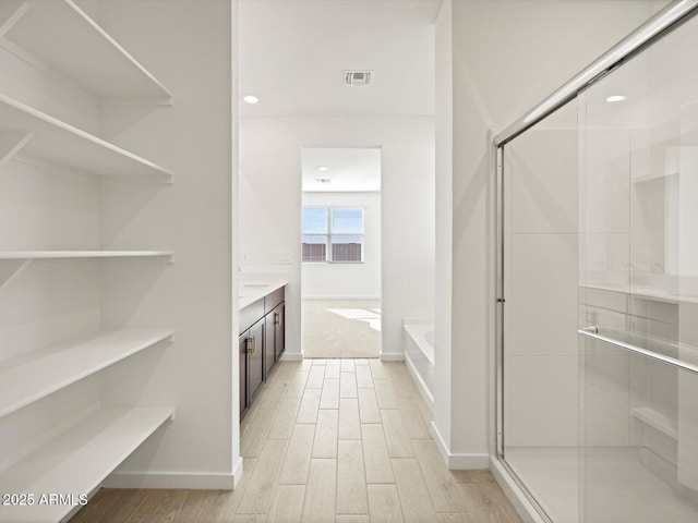 bathroom featuring vanity, hardwood / wood-style floors, and plus walk in shower