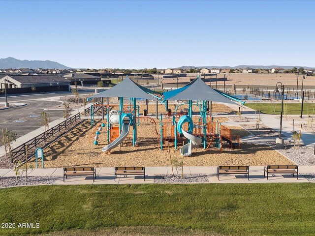 view of playground with a mountain view and a lawn