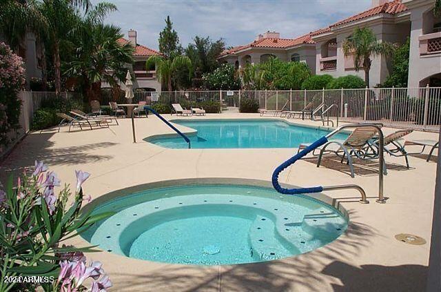 view of swimming pool with a patio and a hot tub