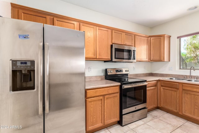 kitchen featuring stainless steel appliances, sink, and light tile patterned floors