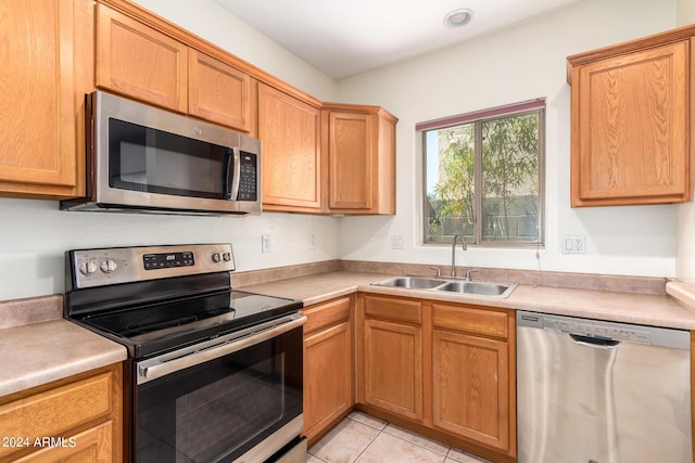 kitchen with light tile patterned flooring, appliances with stainless steel finishes, and sink