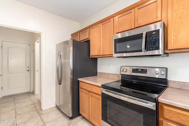 kitchen featuring light tile patterned flooring and appliances with stainless steel finishes