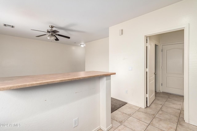 bar with light tile patterned floors and ceiling fan