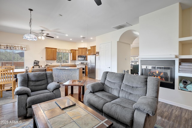 44421 N 12th St, New River, AZ 85087 - living room featuring a ceiling fan, arched walkways, wood finished floors, recessed lighting, and a multi sided fireplace