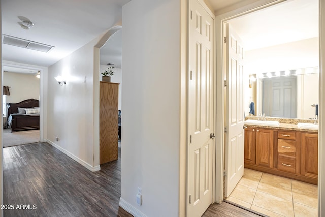 44421 N 12th St, New River, AZ 85087 - hallway with light wood finished floors, baseboards, a sink, and arched walkways
