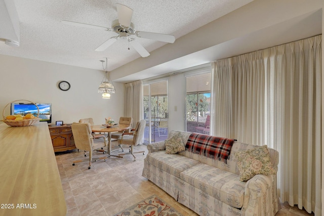 living room with ceiling fan and a textured ceiling