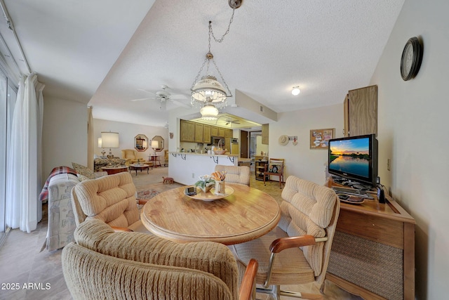 dining area featuring ceiling fan and a textured ceiling