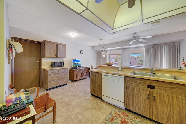 kitchen with sink, ceiling fan, hanging light fixtures, white dishwasher, and a textured ceiling