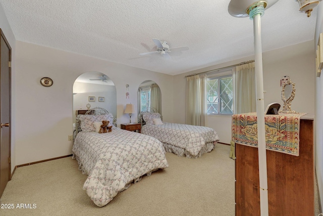 bedroom with carpet floors, a textured ceiling, and ceiling fan