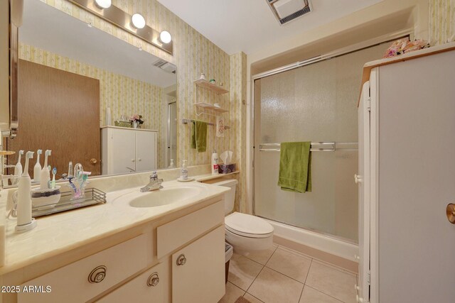 bathroom with tile patterned floors, toilet, a shower with shower door, and vanity