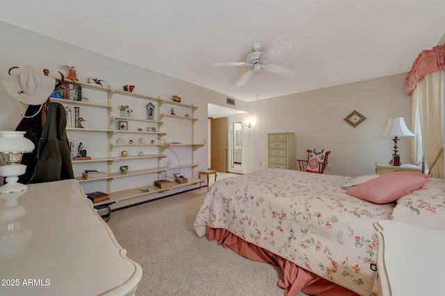 bedroom featuring ceiling fan, carpet flooring, and a textured ceiling