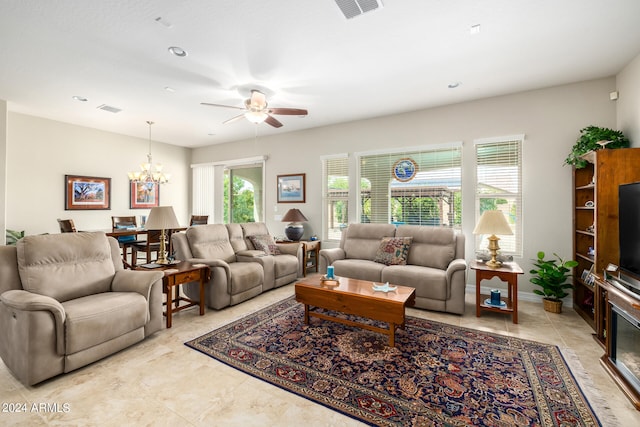 living room with ceiling fan with notable chandelier