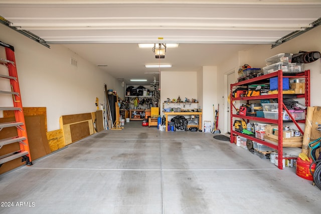 garage with a workshop area and a garage door opener