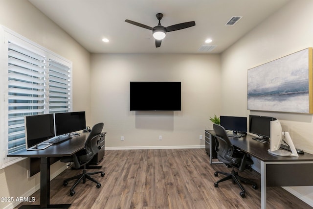 office space with visible vents, ceiling fan, baseboards, and wood finished floors