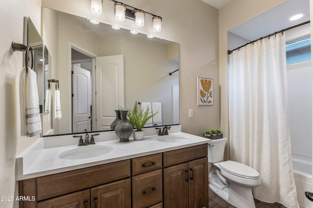 bathroom with double vanity, a sink, and toilet