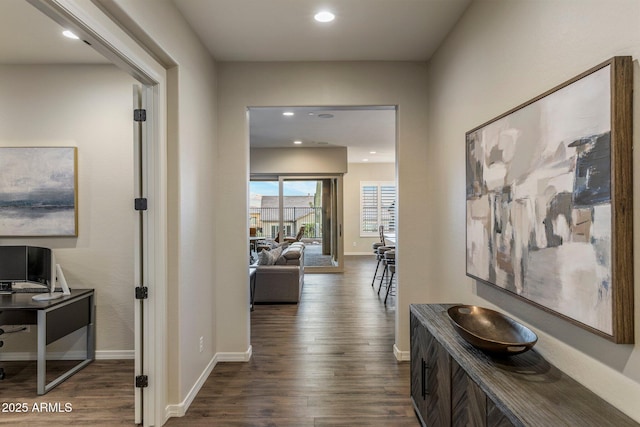 corridor with dark wood-type flooring, baseboards, and recessed lighting