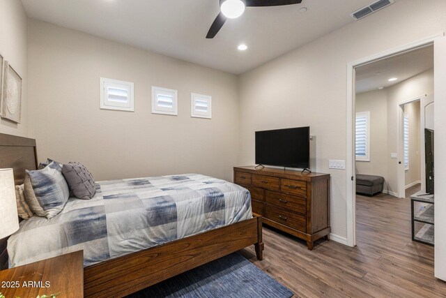 bedroom featuring ceiling fan, visible vents, recessed lighting, wood finished floors, and baseboards