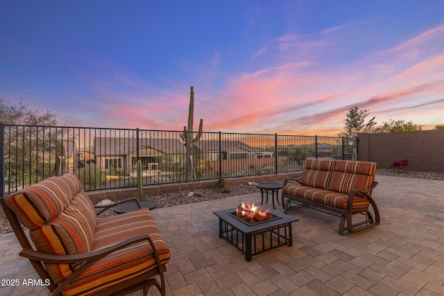 patio terrace at dusk with a fire pit and a fenced backyard