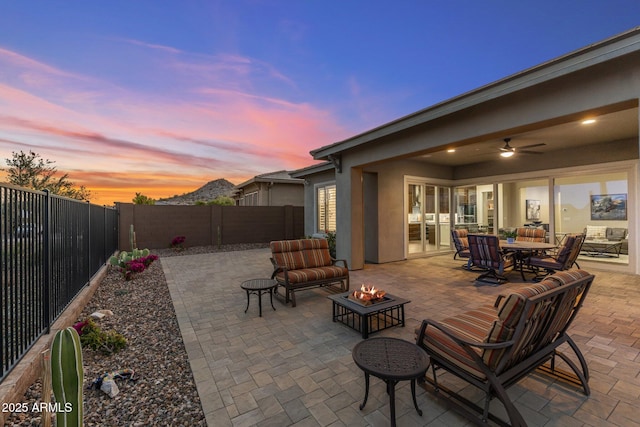 view of patio / terrace featuring an outdoor fire pit, a fenced backyard, and a ceiling fan