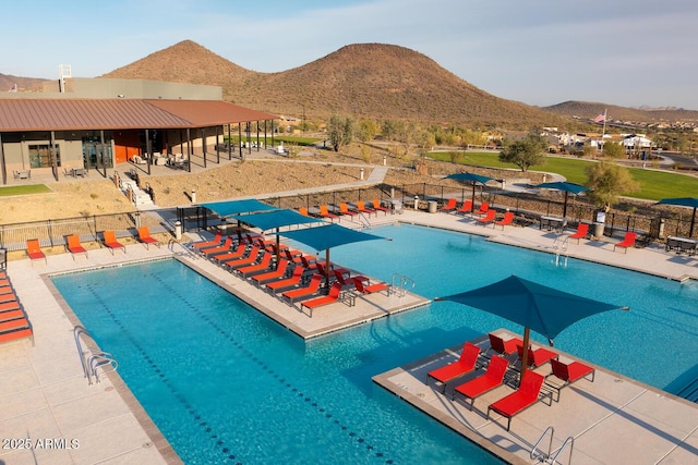 pool featuring a patio, a mountain view, and fence