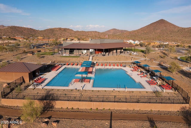 pool featuring a patio area, a mountain view, and fence