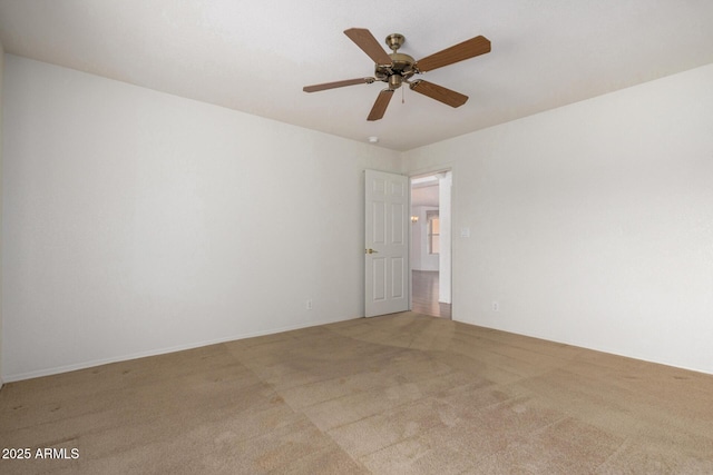 empty room featuring ceiling fan and light colored carpet