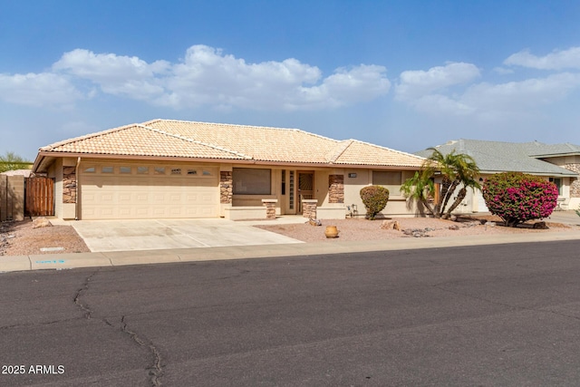 single story home with driveway, stone siding, a tile roof, and a garage