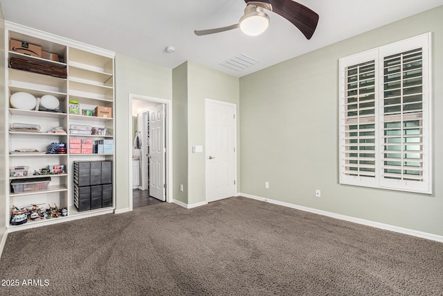 unfurnished bedroom with ceiling fan and dark carpet