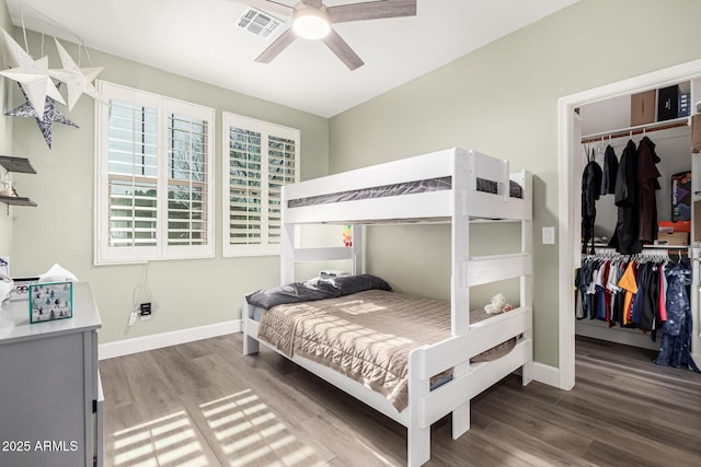 bedroom featuring a walk in closet, wood-type flooring, a closet, and ceiling fan