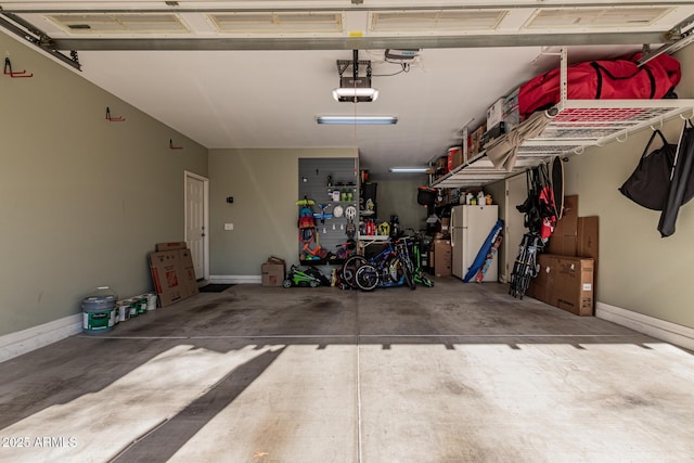 garage with a garage door opener and white refrigerator