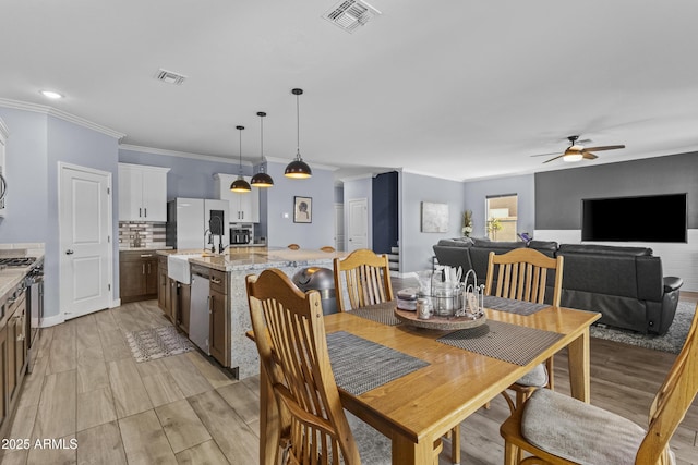 19239 W Elm St, Litchfield Park, AZ 85340 - dining space with a ceiling fan, ornamental molding, and light wood-style floors