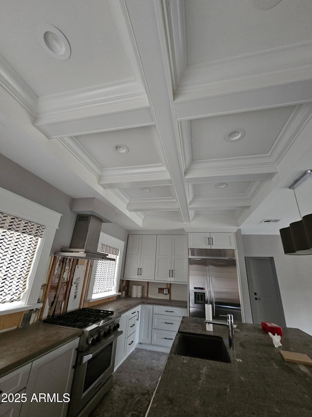 kitchen with appliances with stainless steel finishes, range hood, white cabinetry, sink, and coffered ceiling