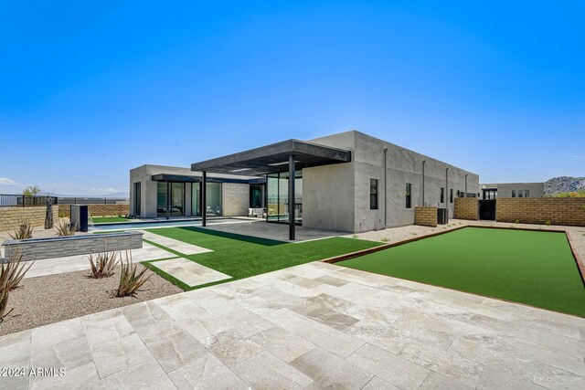 back of house with a patio and a pool