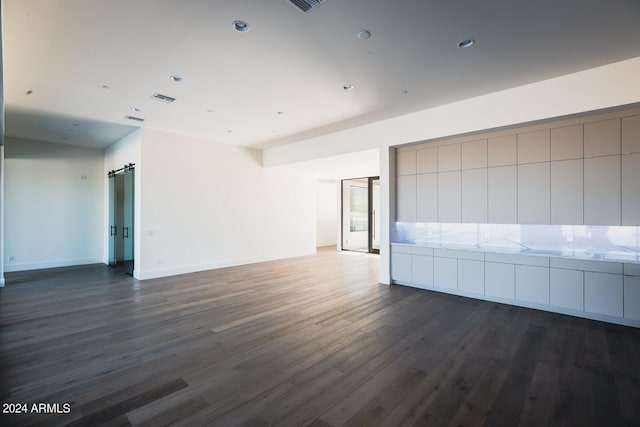 spare room featuring hardwood / wood-style floors and a barn door