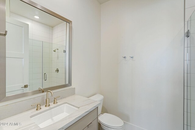 bathroom with vanity, toilet, and a shower with door