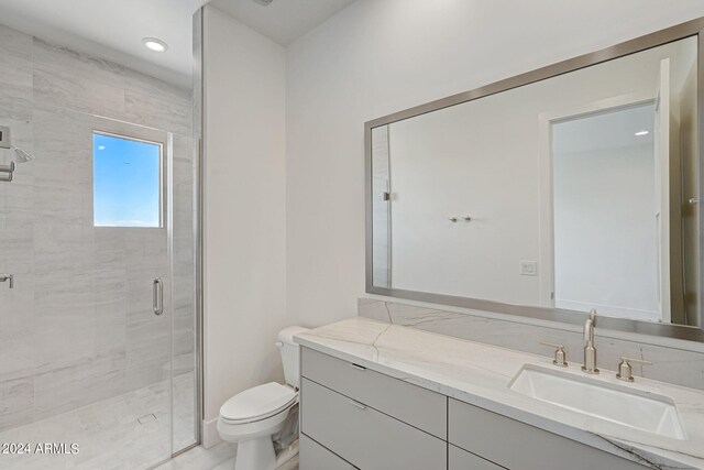 bathroom with vanity, a shower with shower door, and toilet