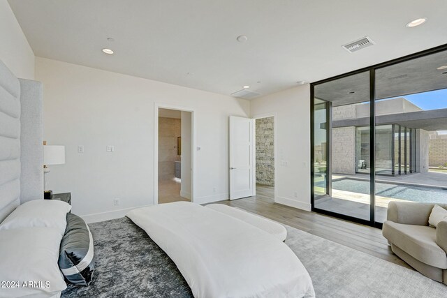 bedroom featuring light hardwood / wood-style floors, access to exterior, and floor to ceiling windows