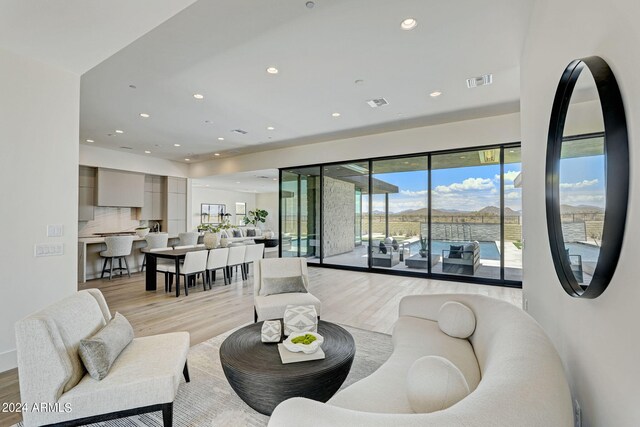 living room with a water view and light hardwood / wood-style flooring