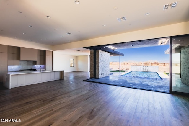 unfurnished living room with sink and hardwood / wood-style flooring